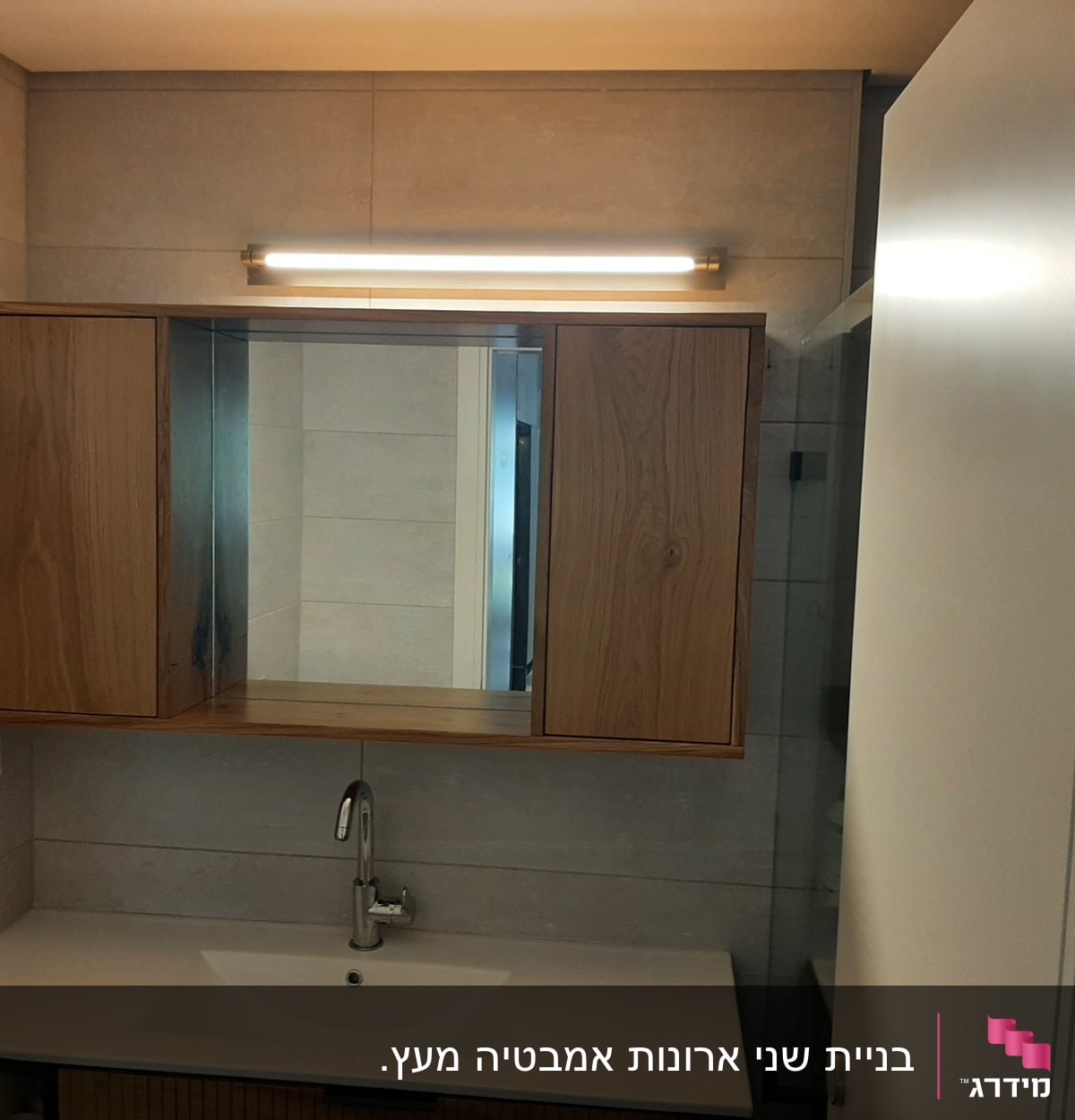 ארון עץ עם מראה ותאורה מעל כיור